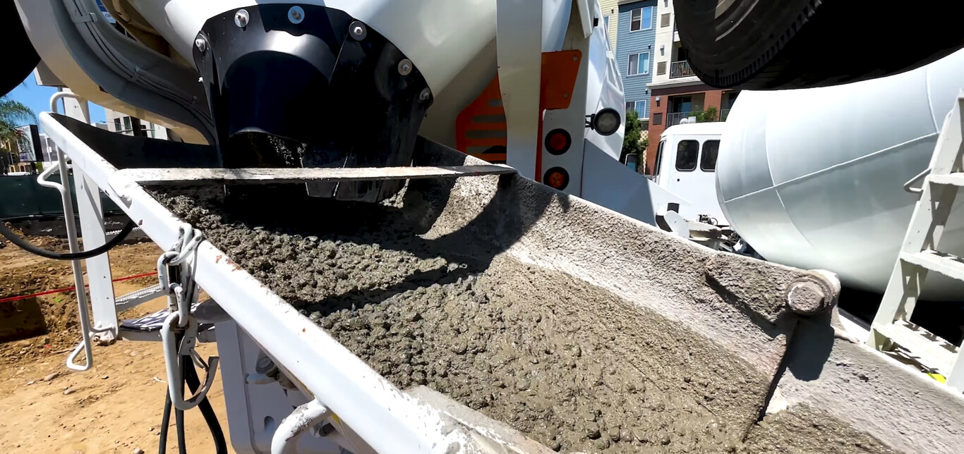 Concrete mixer truck pouring fresh concrete for driveway installation